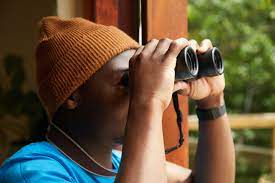 Black man with binoculars near balcony · Free Stock Photo