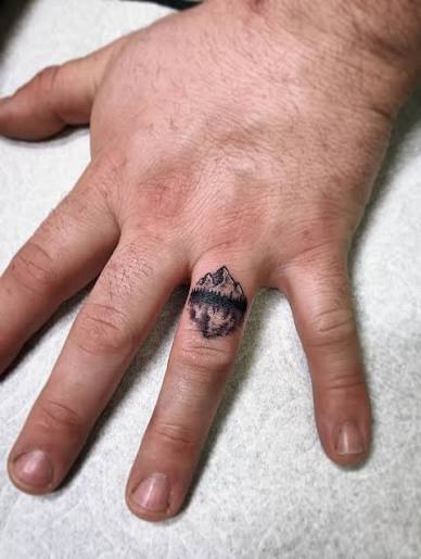 Mountain lake view wedding band tattoos in fine line black and grey 🏔️ 🌲 🏕️ ❤️ (Artist: Marshall Stokes) Finger tattoos, matching tattoos, fine line tattoo shop Carson City, Reno fine line