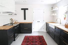 Modern kitchen cabinets coupled with open faced upper cabinets and beadboard backsplash make this kitchen look open, airy, and clean. Kitchens With Black Cabinets