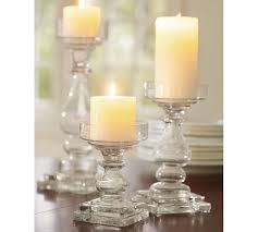 Candles in glass candle holders and a botanical decorative screen in front of them. Clear Glass Square Base Pillar Candleholder Pottery Barn