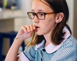 Image of someone holding a giant check, with a confused look on their face