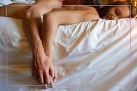 Romantic evening - sexy legs in black fashion as a man hugs a woman on the floor passion