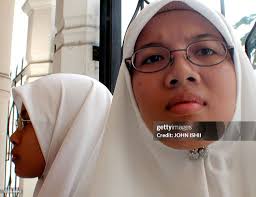 Anfaal Saari and younger sister Marawah Saari wait in front of the...  Fotografía de noticias