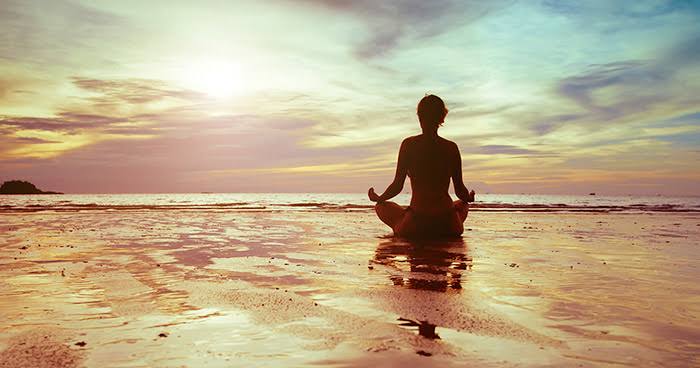 Pessoa meditando em um ambiente calmo em casa para aliviar a ansiedade