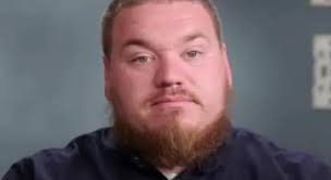 person shoves pumpkin in face