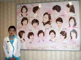 A Member Of Staff Next To A Board Displaying Approved Hairstyles At A Women S Salon In The Munsu Water Park Complex Picture Ca North Korea North Korean Korea