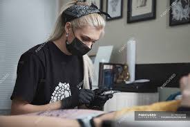 If you have a persistent issue, start using a moisturizer (after exfoliating) that includes some. Tattoo Artist In Mask Preparing Machine While Sitting By Customer At Studio Technology Lying Down Stock Photo 196302558