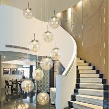 Modern living room with white sleek seats and on a gray shaggy rug illuminated by a chandelier that hung from the high ceiling. Duplex Staircase Chandelier Modern Living Room Lighting Restaurant Art Chandelier Creative Rotating Crystal Chandelier Buy Crystal Chandelier Chandeliers Chandeliers Modern Luxury Staircase Chandelier Product On Alibaba Com