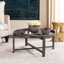 I have a vintage art moderne glass, leather, and brass with a great patina coffee table in my lr that was $25 at goodwill. Safavieh Cursten Rustic Dark Grey Round Coffee Table
