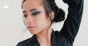 A woman with black makeup and a black blazer photo