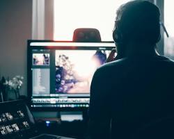 person editing a photo on a computer resmi