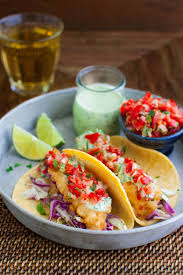 Beer battered fish with a secret garlic cilantro sauce, guacamole, and salsa. Beer Battered Fish Tacos With Cilantro Lime Sauce Taming Of The Spoon