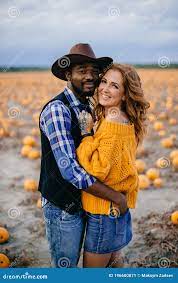 A Loving Couple in a Pumpkin Field. Stock Image - Image of country, cloudy:  196600871