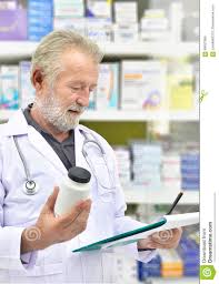 Senior Doctor Looking Medicine Bottle And Patient Chart On