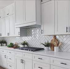 For a more natural look, some homeowners opt to pair their white kitchen cabinets with a stacked stone backsplash. Photo Credit Stix Development This Kitchen Proves That A Herringbone Pattern Makes A Kitchen Backsplash Trends Kitchen Tiles Design Kitchen Backsplash Designs