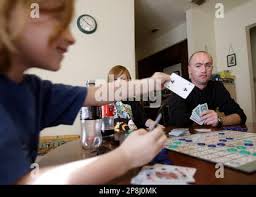 In this March 2, 2009 photo, Sgt. Darron Mikeworth, right, plays a board  game with his family in San Antonio. At left is his son Ryan,7, and son  Connor is center. Mikeworth lost an eye, his nose, and broke every bone in  his face when he was attacked by a ...
