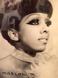 A Photograph of Marlow Monique Dickson Looking Back at the Camera in a  Black and White Dress