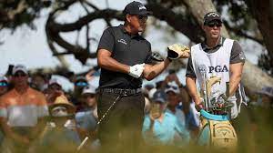 Phil mickelson of the united states pulls a club on the 12th tee as caddie tim mickelson looks on during the final round of the 2021 pga championship held at the ocean course of kiawah island golf. Af2rcbauik2s1m