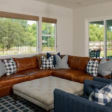 This soft brown sectional sits in front of a dark backed display that has a bronze frame and detailing. Photos Hgtv