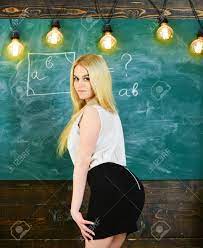 Lady Sexy Teacher In Short Skirt Looking Back While Explaining Formula.  Sexy Teacher Concept. Woman With Nice Buttocks Teaching Mathematics. Teacher  Of Mathematics Writing On Chalkboard, Rear View. Stock Photo, Picture and