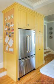 Traditional Yellow Kitchen With A Custom Wood Island Yellow Kitchen Cabinets Yellow Kitchen Refrigerator Cabinet