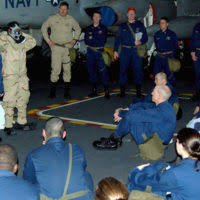 Hull Technician 2nd Class Holly Gardner, left, explains how to don an  Advanced Chemical Protective Garment (ACPG) as Personnel Specialist 3rd  Class Shantrail Robinson demonstrates for a group of Sailors aboard USS