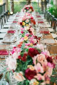 Create a statement table in your reception room by outfitting one table with a tall centerpiece. Elena Damy Long Wedding Tables Red And Pink Flowers Elena Damy Event Design Cabo Elena Damy