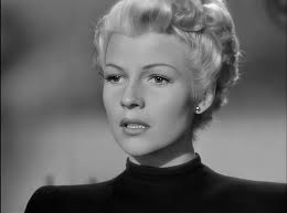 Rita Hayworth. For those that may question this, Rita bleached her hair  blonde when she appeared in the 1947 film The Lady From Shanghai. Beautiful  coat/gown but those sandals! are something else.