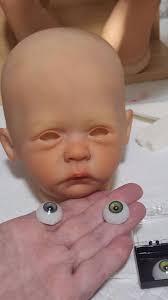 What eye color is more suitable for a baby doll, grey or green?