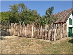 Fence and wooden pole with wild flowers. Wooden Fence Made From Branches Natural Industrial Loft F Rustic Garden Fence Wooden Fence Rustic Fence