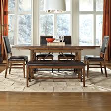 The armless dining chairs flanking the table appear in textural beige upholstery, with similarly dark wood legs. Intercon Santa Clara 6 Piece Dining Table Upholstered Chair And Bench Set Fisher Home Furnishings Table Chair Set With Bench