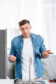 Maybe you would like to learn more about one of these? Confused Man With Repair Tools Looking At Camera While Standing Near Kitchen Sink Free Stock Photo And Image