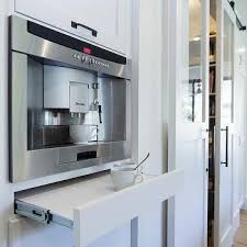 Chic wet bar and butler 's pantry combo features tuxedo cabinets, white upper cabinets accented with x mullion doors over black base cabinets, paired with thick white quartzite countertops and quartzite backsplash. Butlers Pantry Coffee Machine Design Ideas