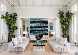 Inspiration for a tropical carpeted, gray floor, vaulted ceiling and wood wall living room remodel in. A Modern Tropical Retreat Epitomizes Coastal Chic Luxe Interiors Design Tropical Interior Design Modern Tropical House Tropical Interior