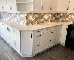 White diamond pattern backsplash tiles finished with light gray grout line a white and gray marble countertop accenting white cabinets fitted with chrome hardware. Diamond Shaped Tile Backsplash Nbizococho
