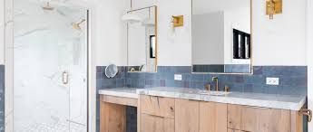 A long rectangular mirror hangs above the marble vanity with a brass faucet. 30 Designer Approved Bathroom Remodel Ideas For 2021