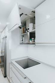 Para los espacios alargados, los diseñadores eligen candiles con una carcasa ligera con varios plafones, y a continuación, los complementan con lámparas en la cabecera de la cama, en la parte de atrás del sofá y encima del escritorio. Cocinas Largas Y Estrechas Con Barra En Madera