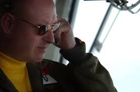 US Navy (USN) Commander (CDR) James Hineline, the"Air Boss"aboard the USN  Nimitz Class Aircraft Carrier USS RONALD REAGAN (CVN 76) adjusts his  headset in preparation of USN Carrier Air Wing 14 (CVW-14) fly off from the  REAGAN. The CVW-14 ...