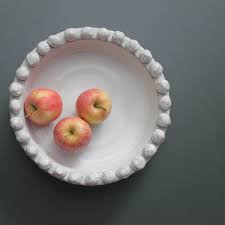 This beautiful abstract bowl makes the perfect centre piece or fruit bowl for your dining room table. Off White Shallow Ceramic Bowl With Bobbles On Rim Two Sizes