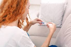 Smiling Redhead Girl Checking Her Recent Pregnancy Test, Sitting On Beige  Couch At Home, Pov Stock Photo, Picture and Royalty Free Image. Image  86552438.
