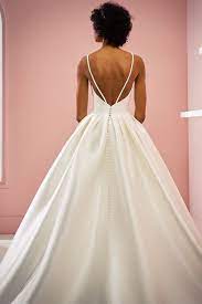 Hd00:08mädchen wählt ein hochzeitskleid in einem hochzeitssalon. Minimalistisches Prinzessinnenbrautkleid Vanessa White One Brautkleid Braut Brautmode