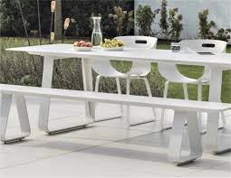 The table is fitted with a matching bench and a set of three metal dining chairs. Alfresco Teak Picnic Bench