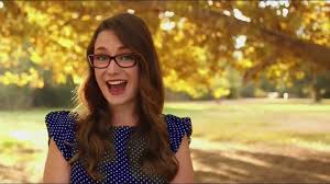 An eyeglasses wearing owl perches on a bench in the park next to a woman reading a book. America S Best Commercial Actors 08 2021