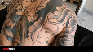 刺青を入れた男とホットなブルネットの女の子がイチャイチャしている