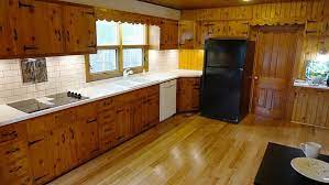 1950s Knotty Pine Kitchen Updated With Solid Surface White Countertops And Subway Tile Backsplash Knotty Pine Kitchen Pine Kitchen Knotty Pine Cabinets
