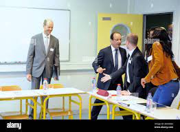 French President Francois Hollande flanked by college Principal, Alain  Ouvrard meets teachers as he visits the Youri Gagarine college, in Trappes,  a Paris suburb, France, on September 3, 2012, as part of