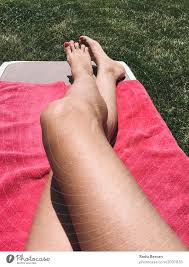 Schönes Mädchen, das ihre Füße auf rosa Tuch im Gras sich entspannt - ein  lizenzfreies Stock Foto von Photocase