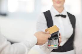 Let your customers tap and go—and keep your line moving fast. Waitress Holding Payment Machine Toward Customer Customer Paying By Contactless Method Stockfoto