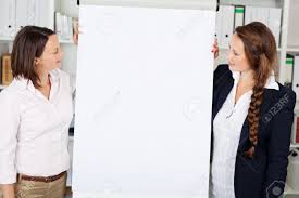 Two Attractive Confident Businesswomen Giving A Flip Chart Presentation