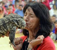 Longmeadow Center School principal Donna Hutton puckers up to kiss lizard  in honor of kids' reading accomplishments